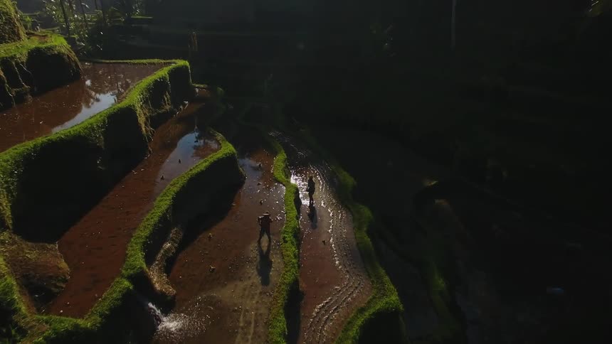 A view of  a mountain or something with ledges and water and people are standing on it