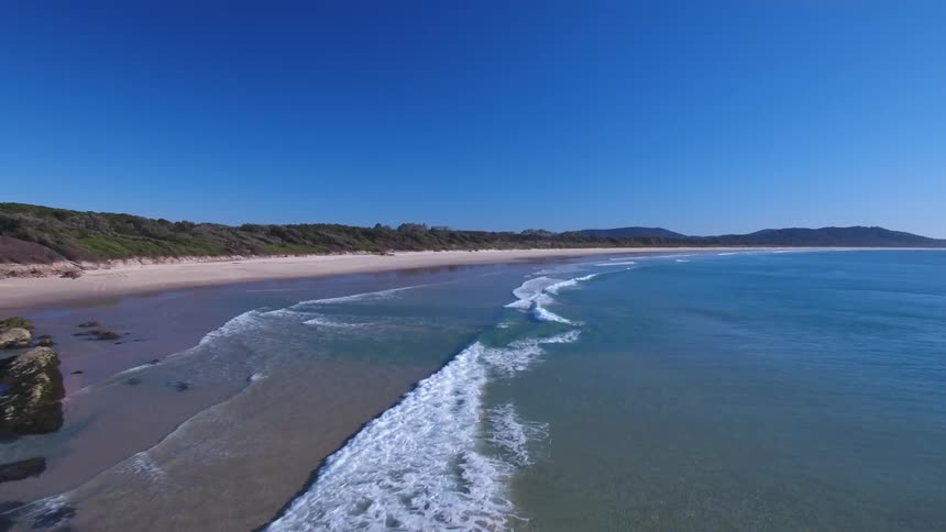 The waves slowly hit the shore of the large beach