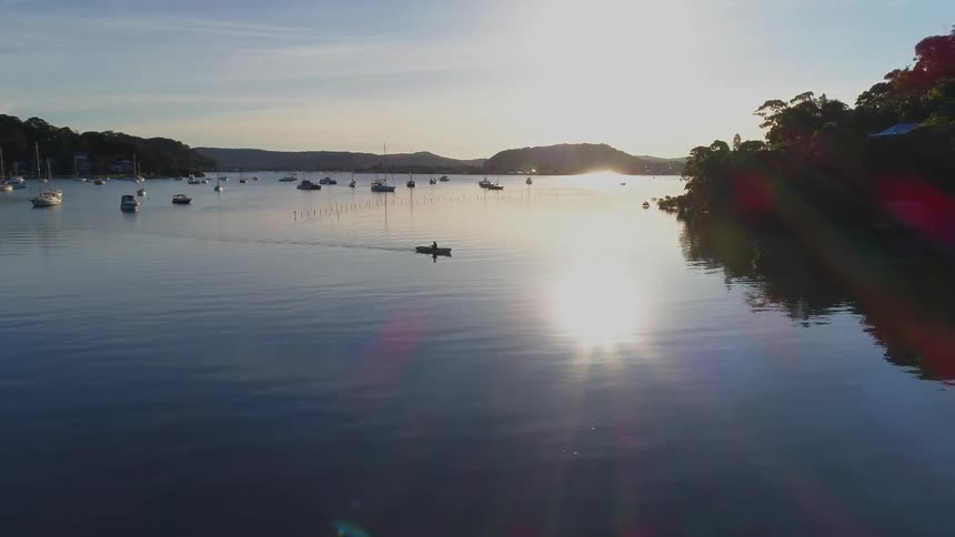 A rowboat glides across a rippling lake