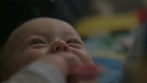 A baby is happy laying in bed