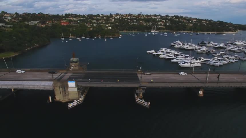 An overhead side view of cars driving across a bridge over water