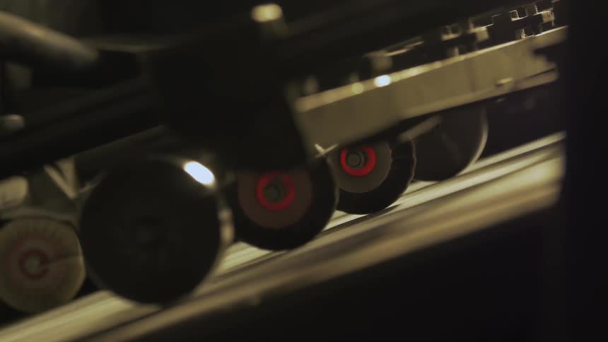 A machine is rolling papers down it's assembly line