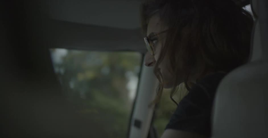 Woman sits in passenger seat and talks with driver