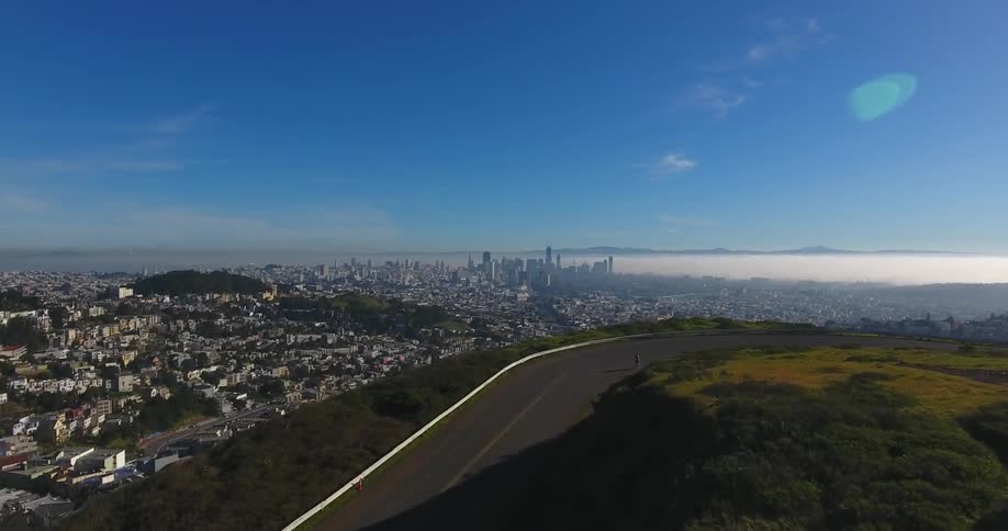 Over the top of this green hill is a city ahead