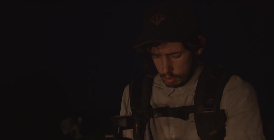 Worried looking man stands outside in the dark