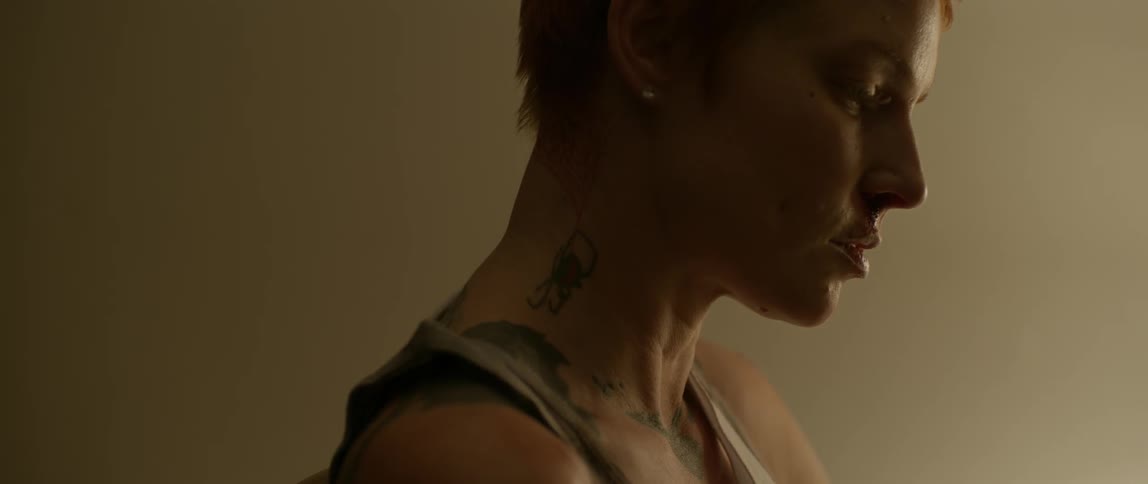 A woman is looking down in a dark room