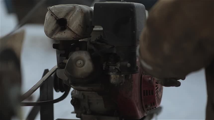 Person pulls a cord to start an engine