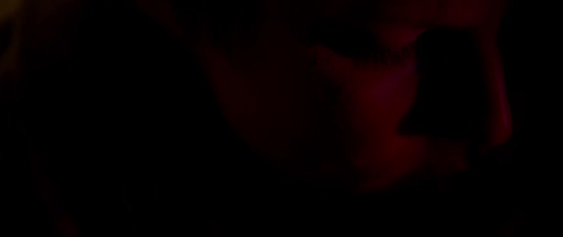 Police lights flash on a woman's face at night