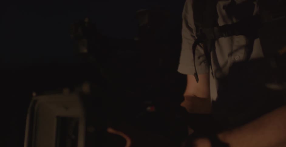 Two men holding camera equipment in the dark