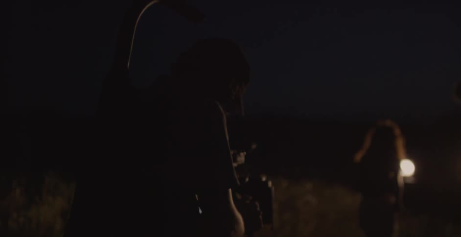 People outside with camera equipment in the dark