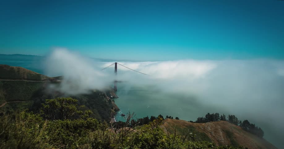 Clouds form and float around a city bridge