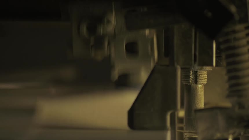 A machine is stamping fabric is as it goes past