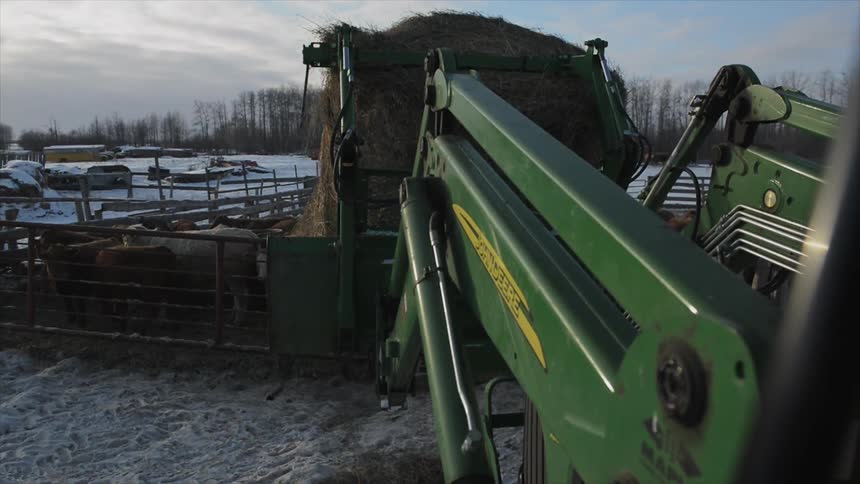 Farm equipment moves a load of hay
