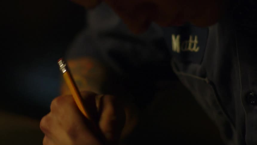 A man is writing something in a dark room