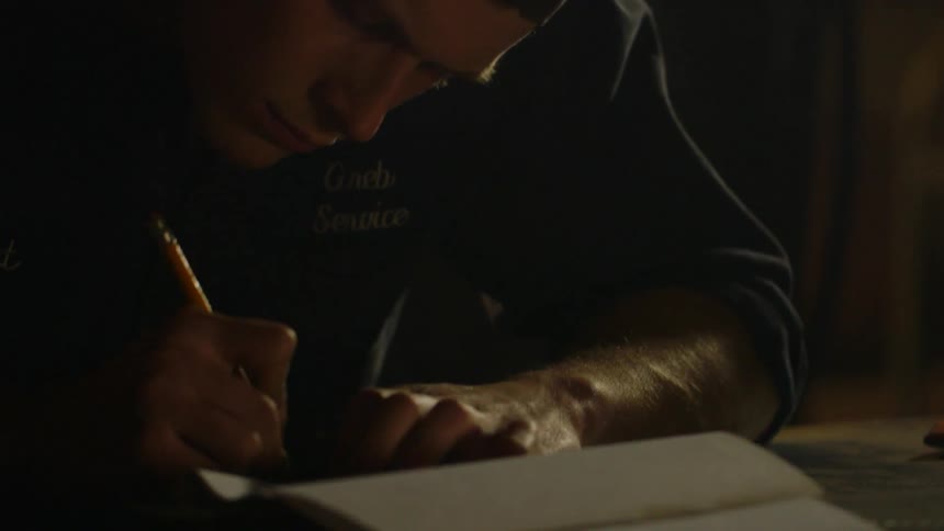 A man drawing on paper inside a shop