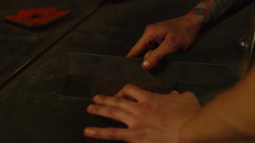 A man is placing a piece of metal on a slab
