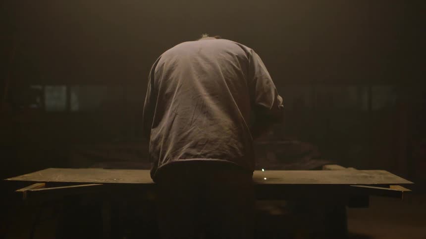Man welding a large piece of sheet metal