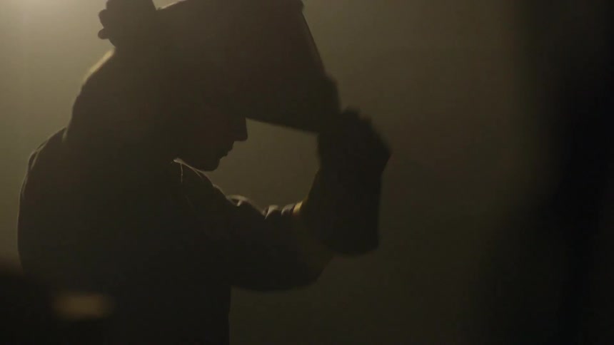A man lifts his welders mask up and wears it