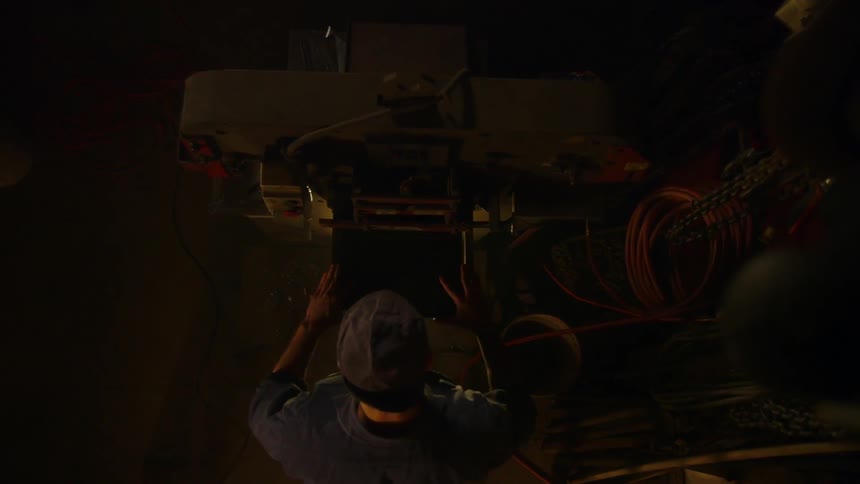 A man standing in a garage is opening a case
