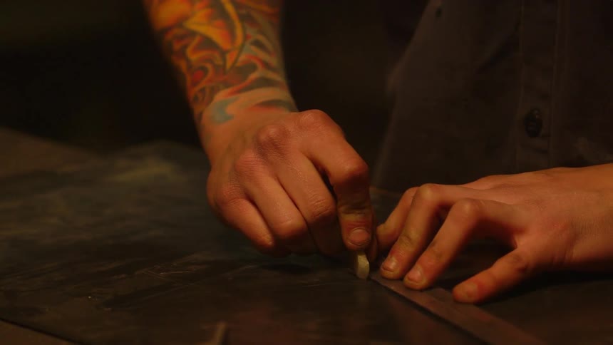 A man traces a line with a ruler