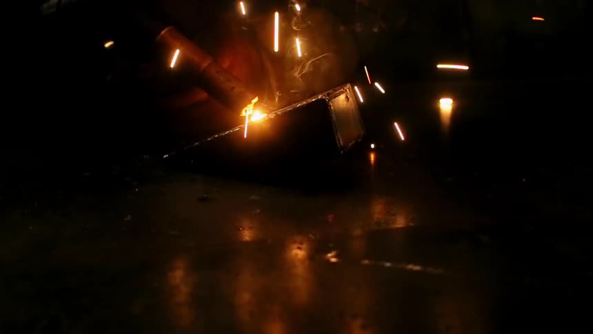 A man is welding a small piece of metal