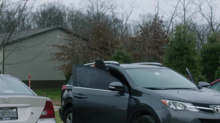 A man and woman get out of an suv