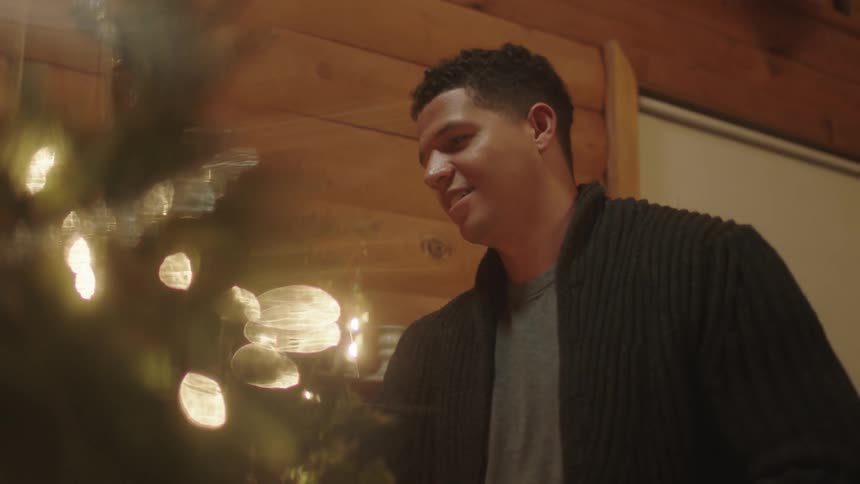 A man smiles as he looks at his christmas tree