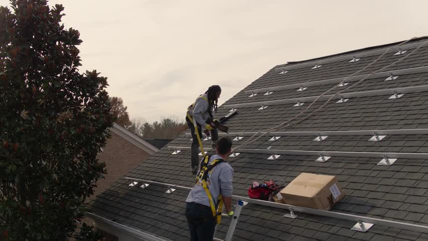 Two men fixing a roof
