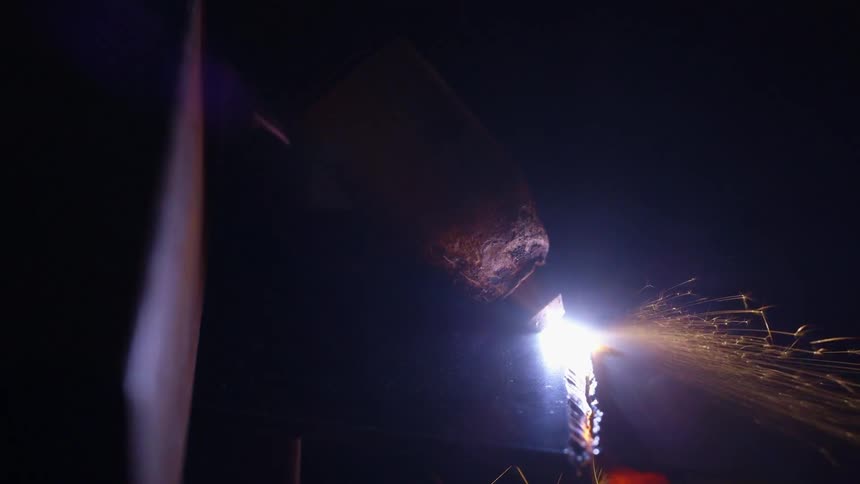 A man grinding a piece of metal and making sparks