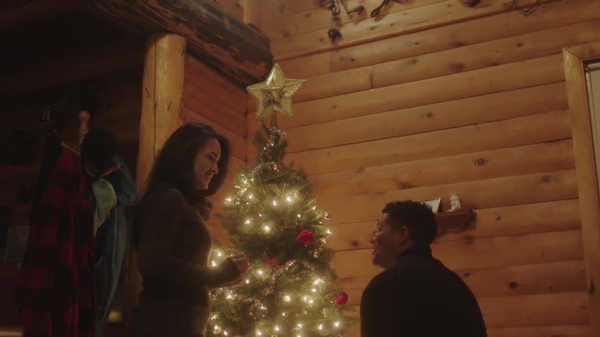 A couple talk by their christmas tree