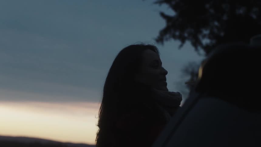 Woman outdoors near a tree near sunset