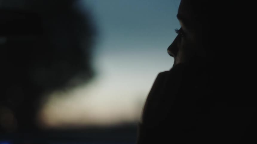 A woman talks on her phone at dawn