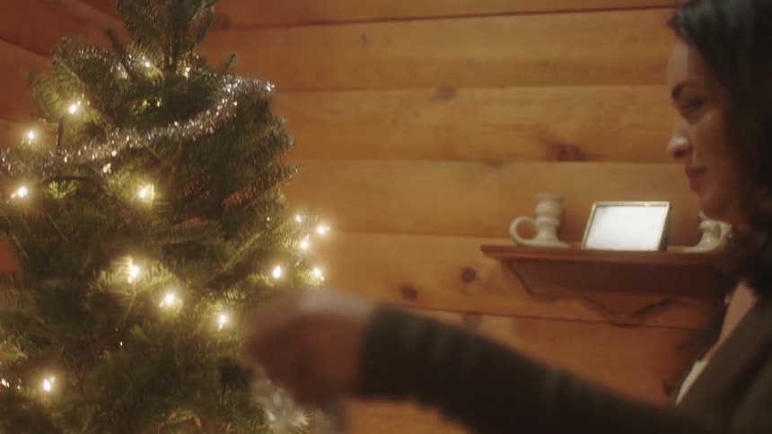 Man and woman decorate a christmas tree together