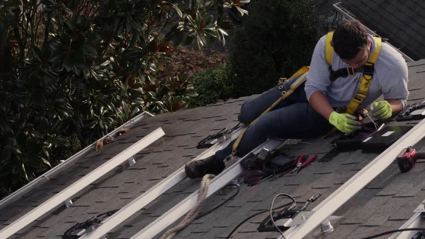 A man is working on installing a solar system on a rooftop