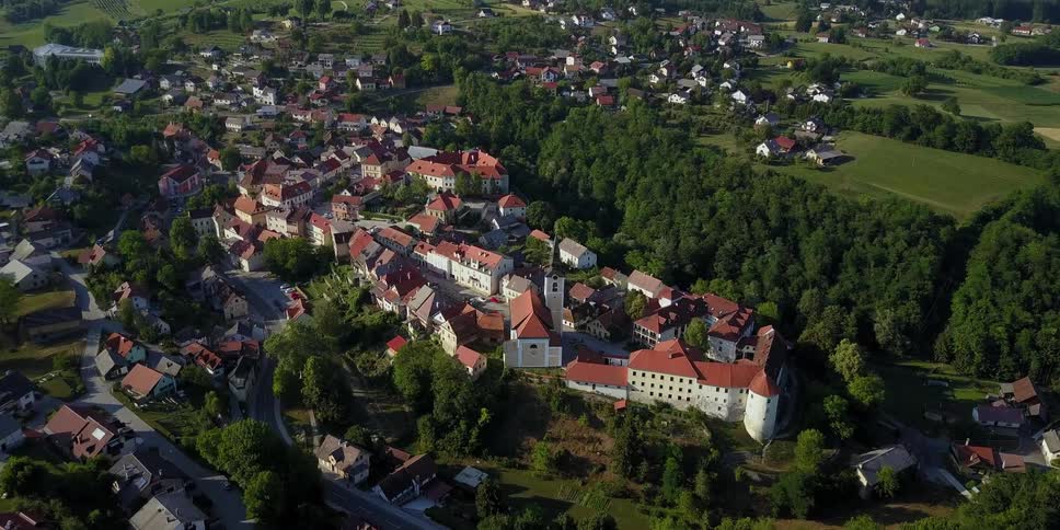 A town with buildings and houses are on the green hill