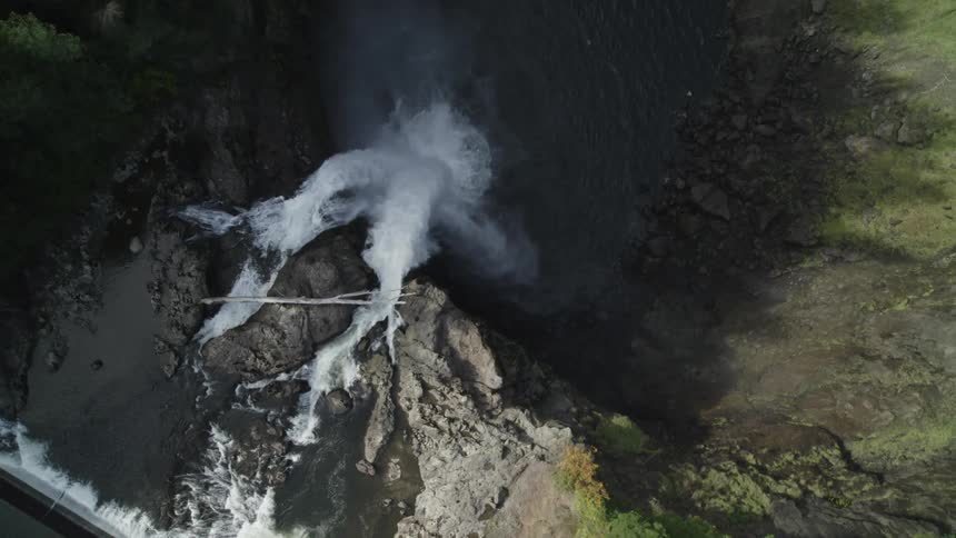 Orbit around water cascading down into a plunge pool below