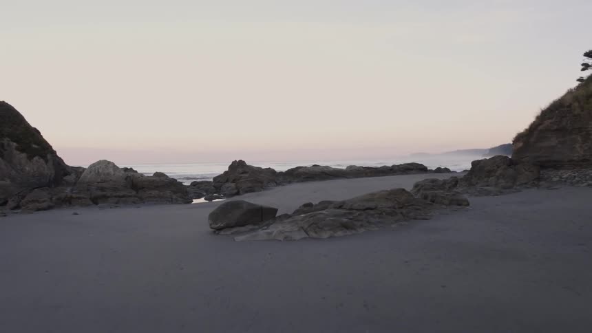 Skimming along a pristine beach over tide pools and gentle waves washing ashore