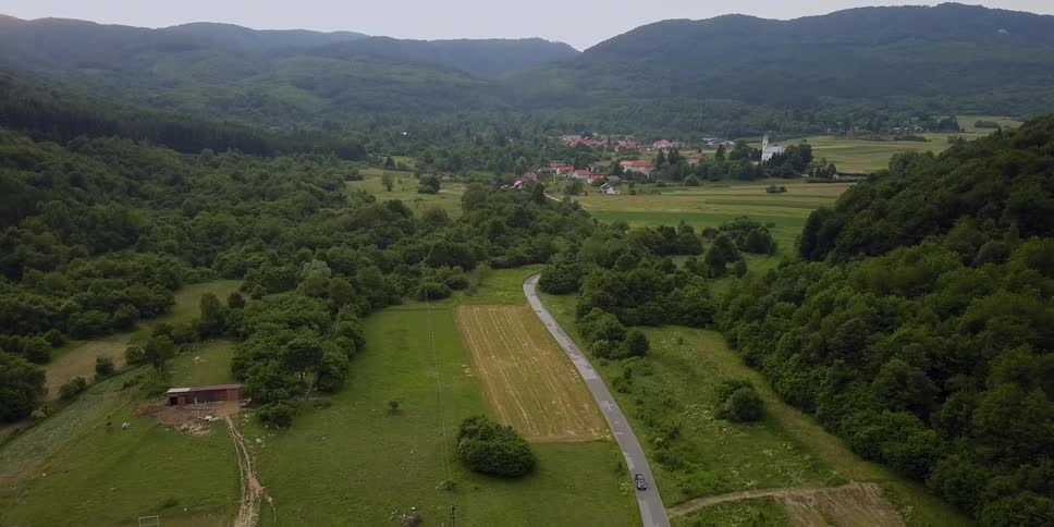 A car is leaving on a small road from the town