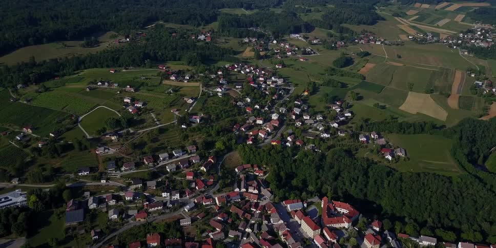 There is a small town below with hills all around