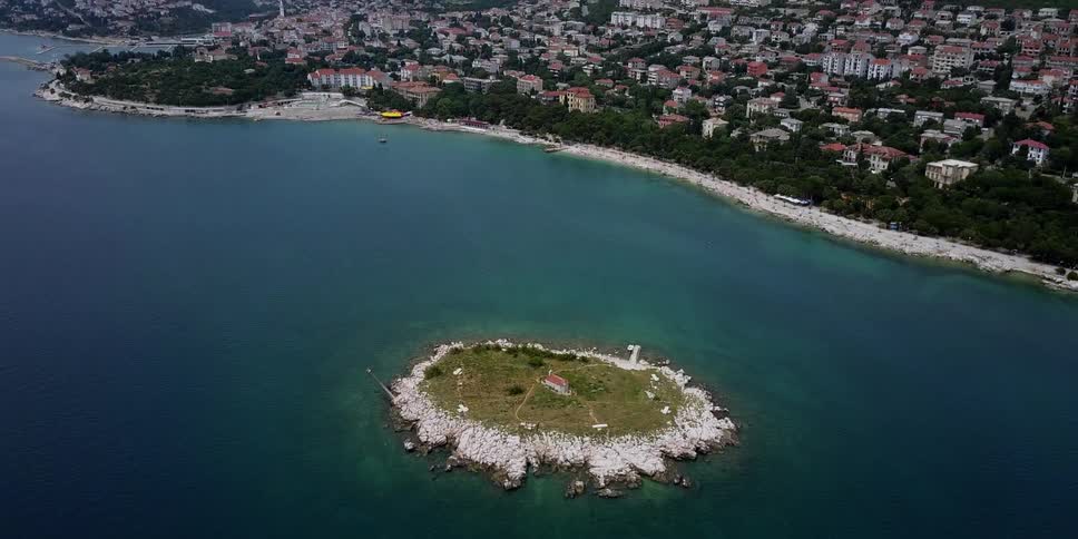 A small island is shown off the coast of a coastal city