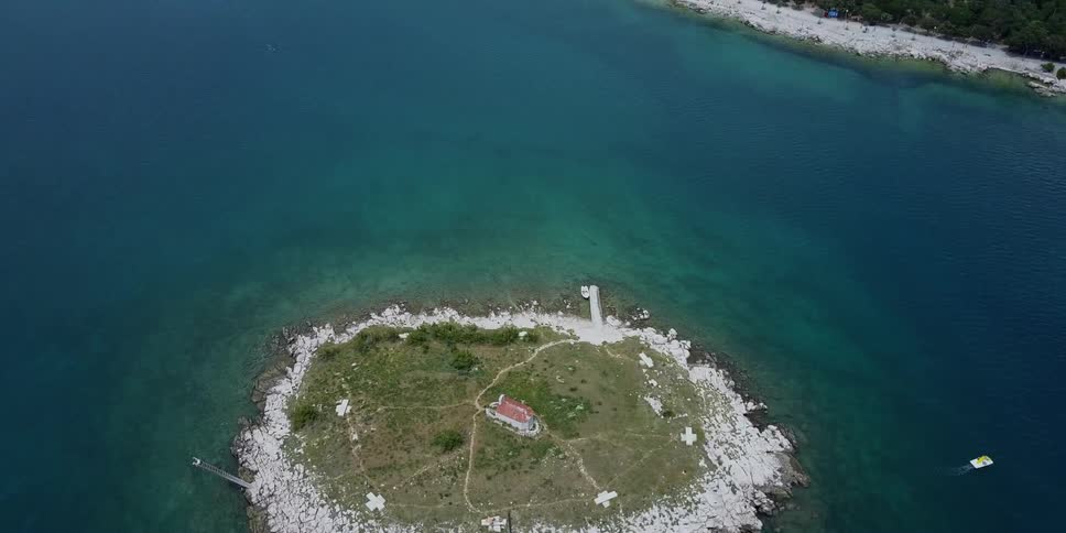 A small island has a single house near the coast
