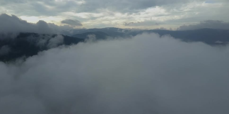 Large clouds fill the sky on top of these mountains