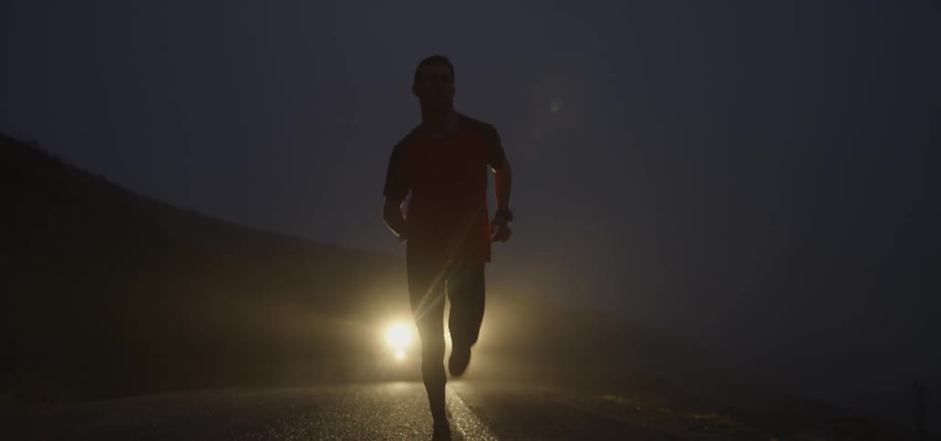 A man is running as a car follows behind