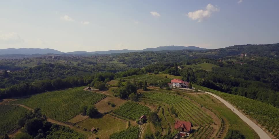 The tall hills lead to some homes and a forest