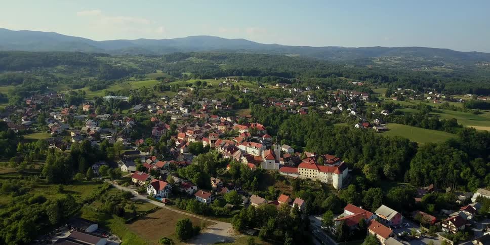 Below is a town with houses and buildings with red roofs