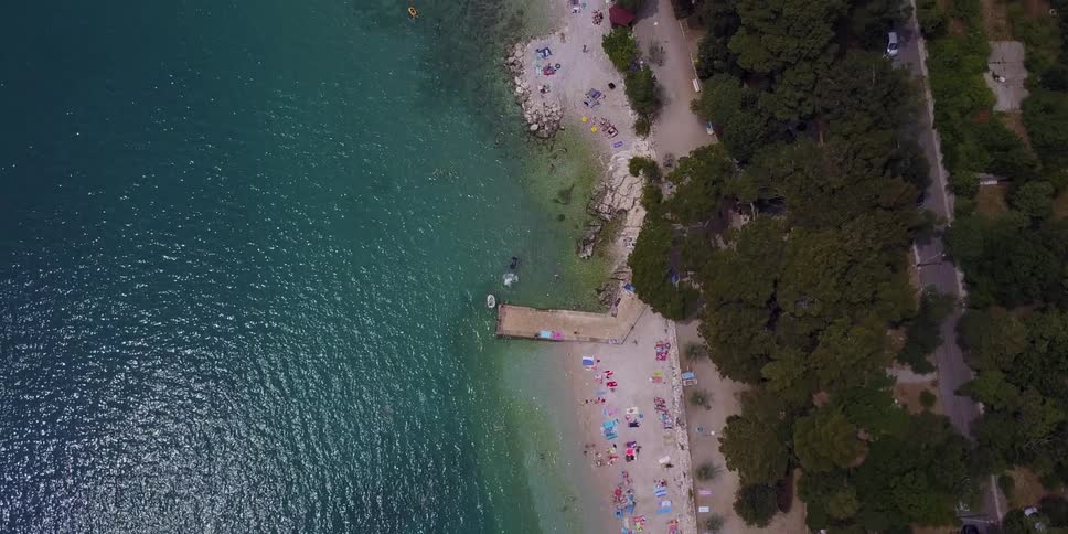 The beach below has many people by the water