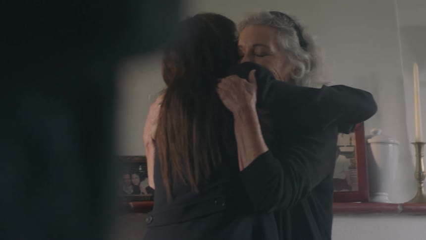 A woman talks and hugs a woman