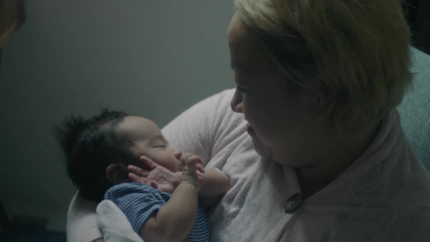 A woman is holding a baby smiling