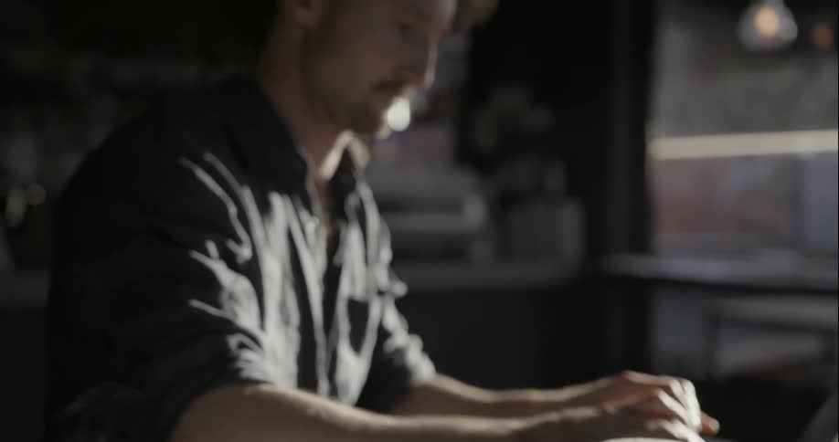 A man works on a laptop in a coffeeshop