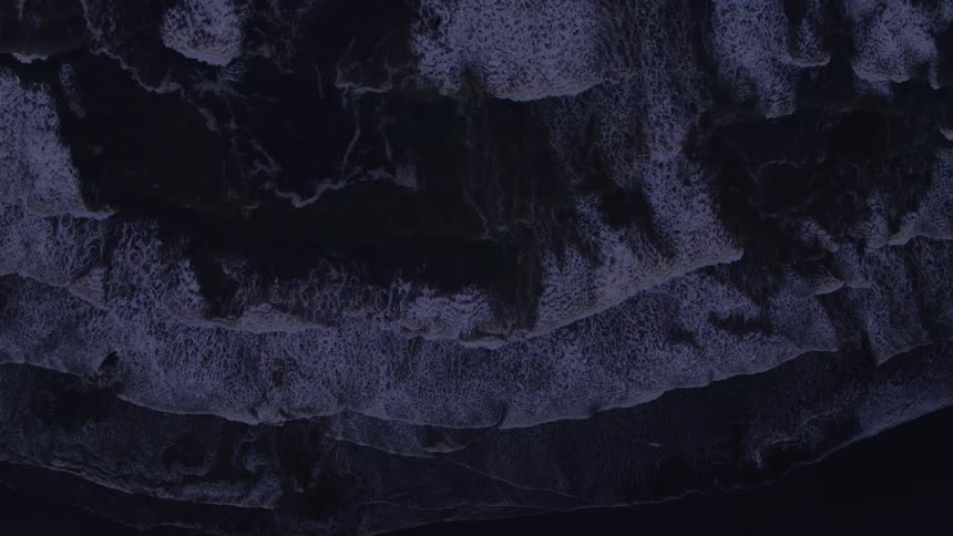 Traverse high above ocean waves slowly washing ashore at night